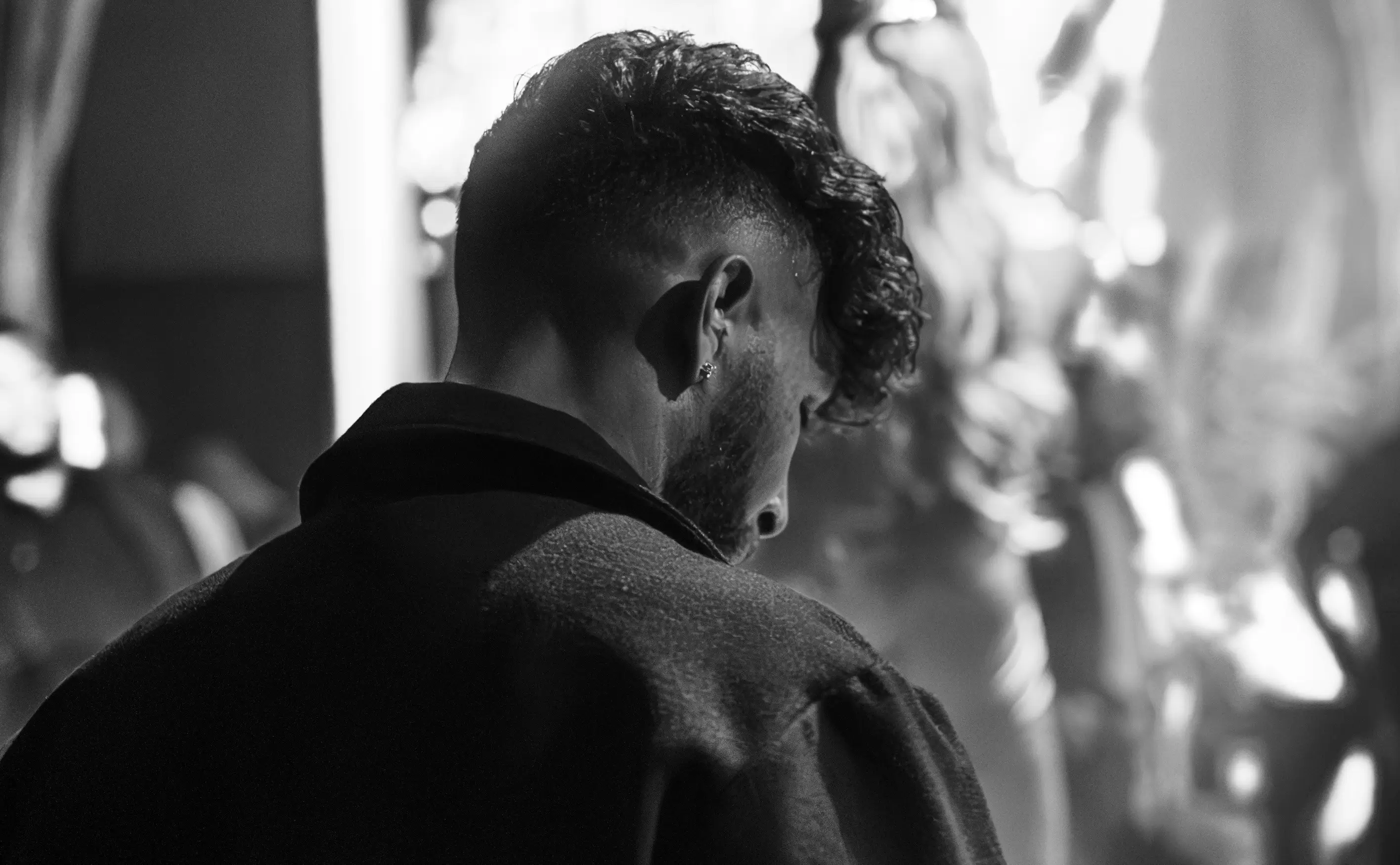 photo of dj's back working while also capturing the crowd vibing and the glowing atmosphere